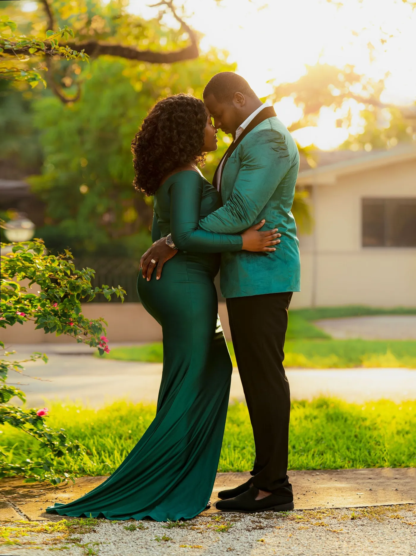Pareja abrazada frente con frente, ella con vestido verde esmeralda largo y él chaqueta verde, de Photoluv Studios en Miami